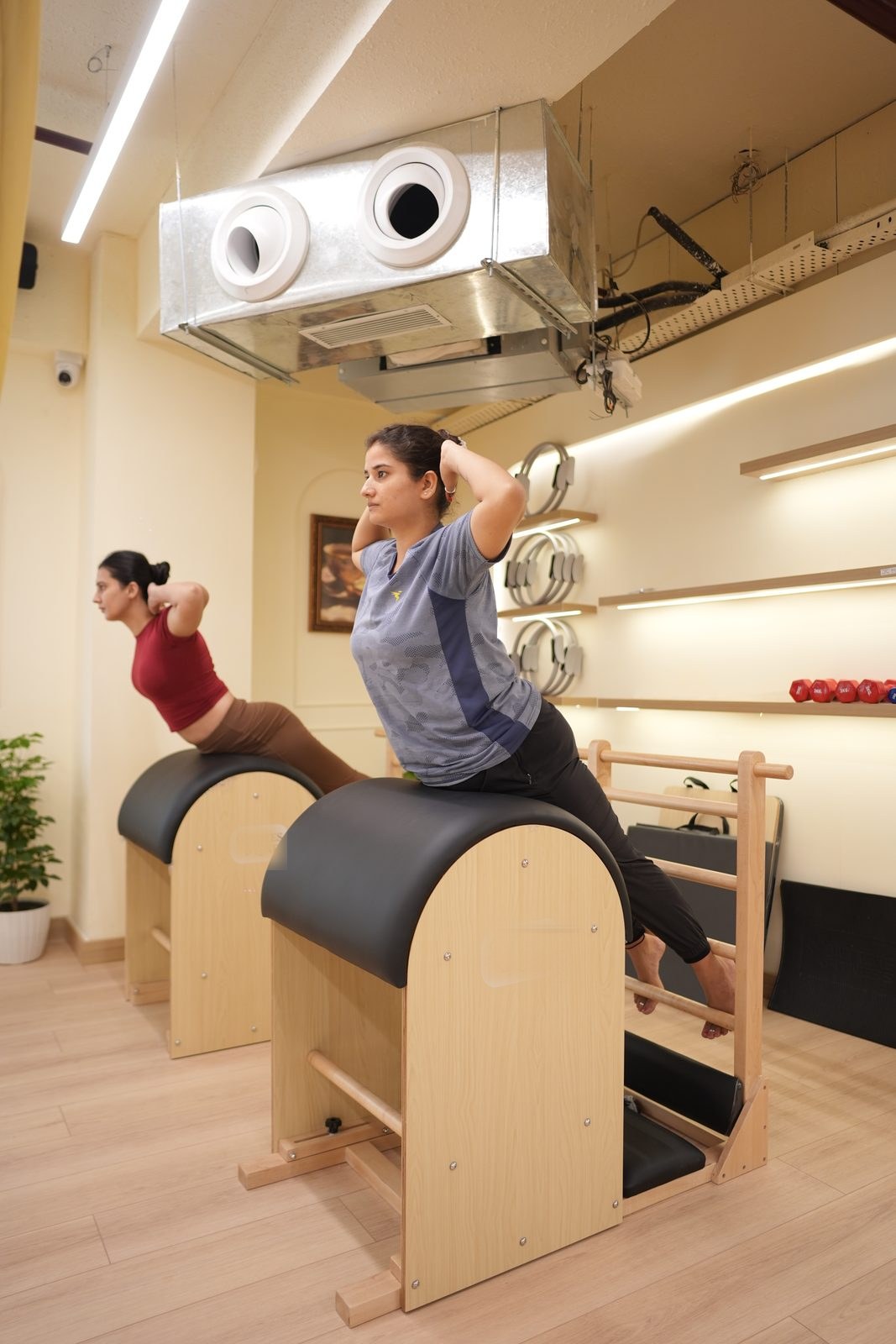 Two clients working through a spine extension on ladder barrels side by side